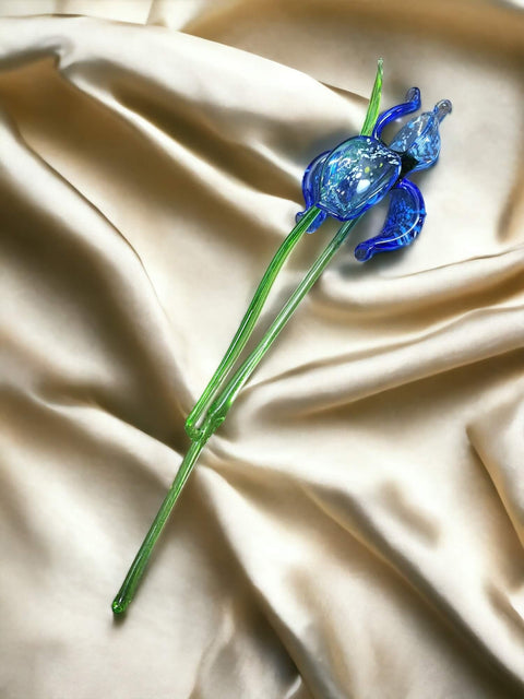 a blue flower sitting on top of a white cloth