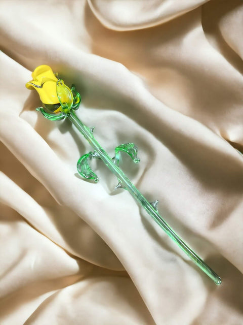 a yellow rose sitting on top of a white sheet