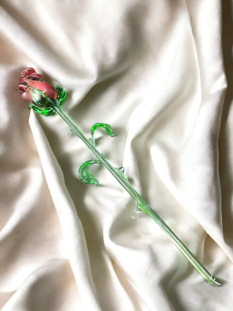 a single rose sitting on top of a white sheet