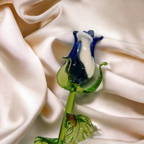 a glass flower sitting on top of a white cloth