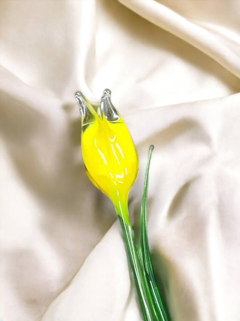 a yellow flower sitting on top of a white sheet