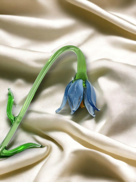 a blue flower sitting on top of a white cloth