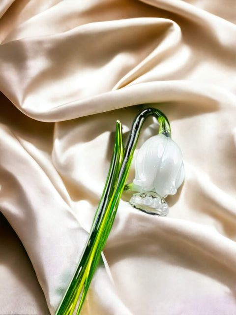 a single white flower on a white cloth