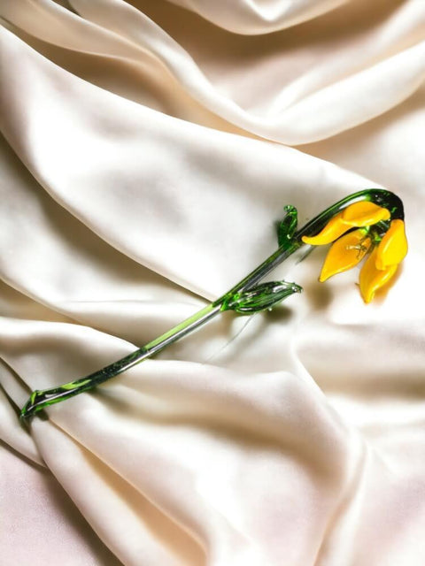 a single yellow flower on a white cloth