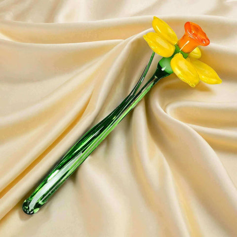 a yellow and orange flower sitting on top of a white cloth