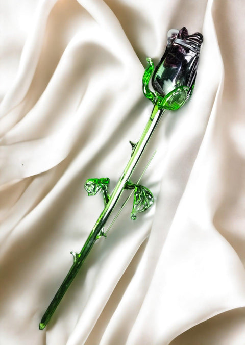 a green glass pipe laying on top of a white cloth