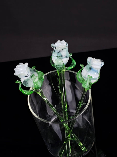 a glass vase with three flowers in it