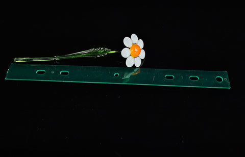 a flower sitting on top of a green piece of plastic