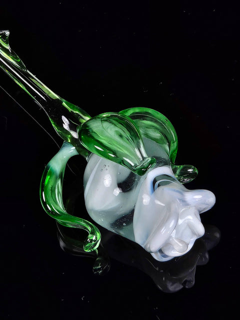 a green and white glass sculpture on a black surface