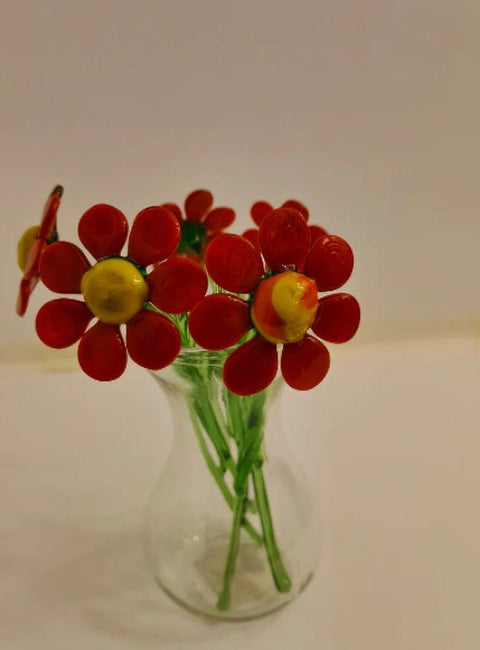 a glass vase filled with red and yellow flowers