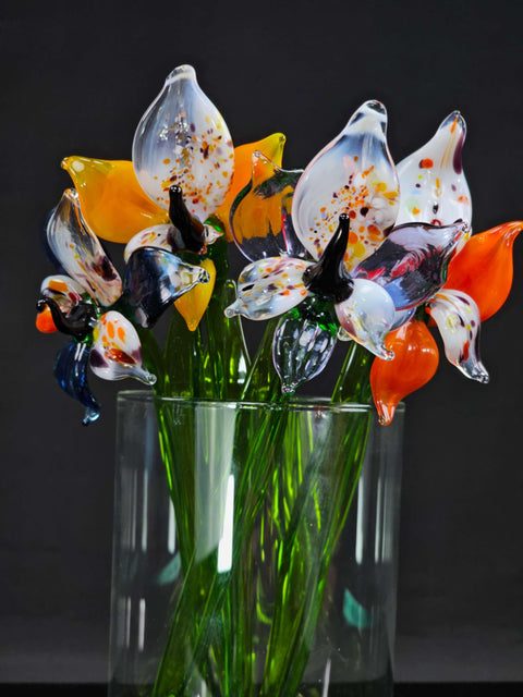 a glass vase filled with colorful flowers on top of a table