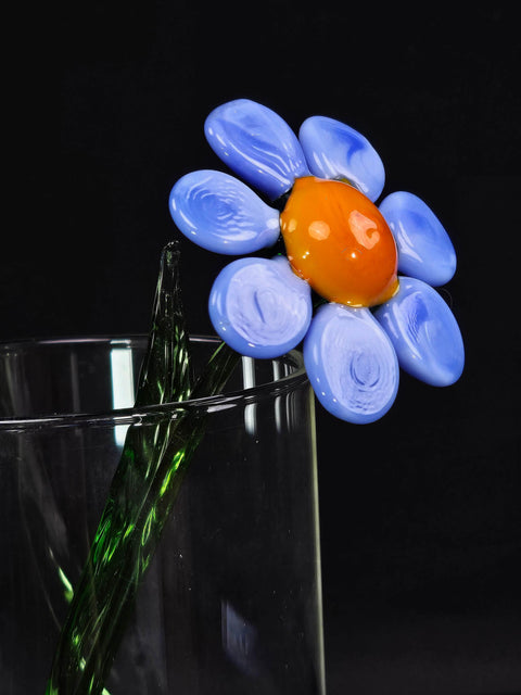 a glass vase with a flower in it