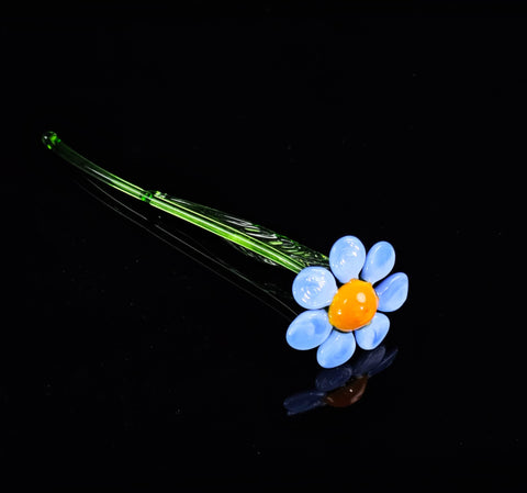 a blue and yellow flower sitting on top of a black surface