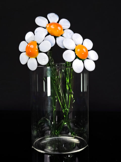 a glass vase filled with white and orange flowers