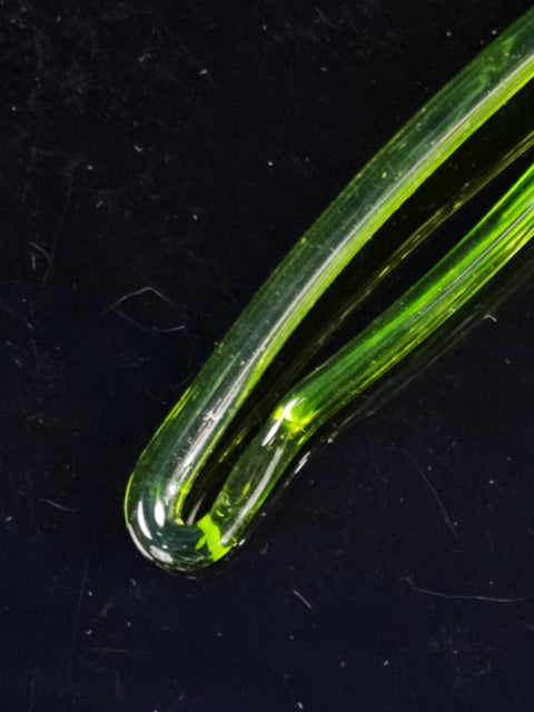 a close up of a green object on a black surface